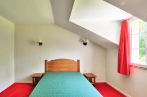 um quarto com uma cama verde e uma janela em La résidence du Lac - maeva Home - Appartement 2 pièces 5 personnes - Sél 674 em Monflanquin