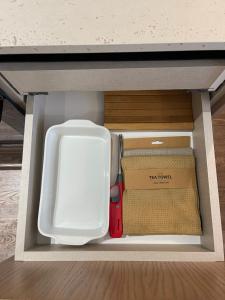 an open drawer with a white refrigerator and a box at Square INN Garden Aparthotel in Tirana