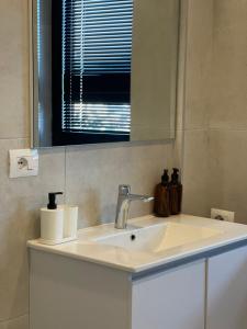 a bathroom with a sink and a mirror at Square INN Garden Aparthotel in Tirana