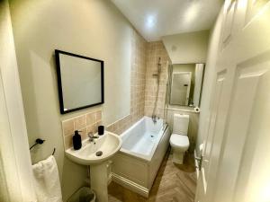 a bathroom with a sink and a tub and a toilet at Stone Villas By Alternative Stays in Hednesford