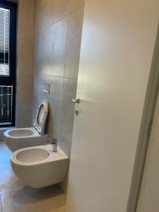 a bathroom with a toilet and a sink at Square INN Garden Aparthotel in Tirana
