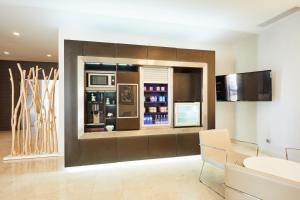 a living room with a large window and a kitchen at Silken Turcosa in Castellón de la Plana