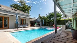 a swimming pool in a backyard with a house at Franschhoek Homestead in Franschhoek