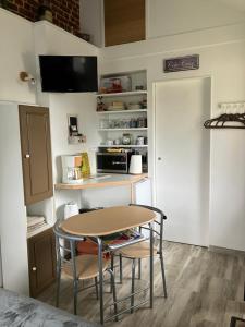 eine kleine Küche mit einem Tisch und 2 Stühlen in der Unterkunft La Marokanette in Saint-Maclou-de-Folleville