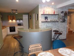 a kitchen with a counter and stools in a room at le gite de la douceur d'antan in Roquetoire