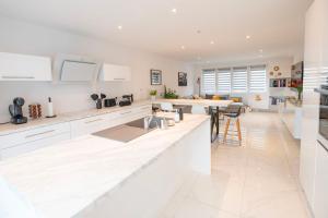 a kitchen with white cabinets and a long counter at LA PARENTHESE in Tournai