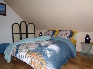 a bedroom with a bed with a blue comforter at le gite de la douceur d'antan in Roquetoire