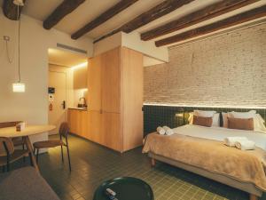 巴塞罗那Boutique Apartments 23 Barcelona的一间带床和砖墙的卧室