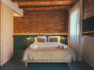 ein Schlafzimmer mit einem Bett und einer Ziegelwand in der Unterkunft Boutique Apartments 23 Barcelona in Barcelona