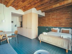 ein Schlafzimmer mit einem Bett und einem Tisch in einem Zimmer in der Unterkunft Boutique Apartments 23 Barcelona in Barcelona