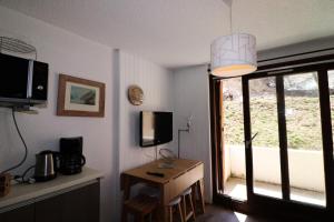 a room with a table and a television and a window at Résidence Olympiques - Studio pour 5 Personnes 484 in Tignes