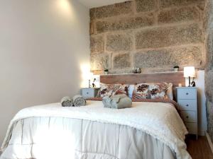 um quarto com uma cama grande e uma parede de pedra em Galician Holiday Home em Villariño