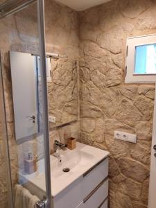 a bathroom with a sink and a stone wall at Galician Holiday Home in Villariño
