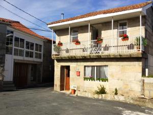 uma casa com vasos de plantas na varanda em Galician Holiday Home em Villariño