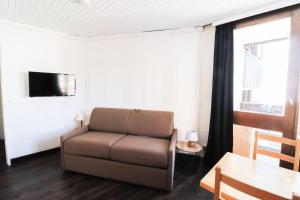 a living room with a couch and a table at Résidence Sefcotel - Studio pour 4 Personnes 574 in Tignes