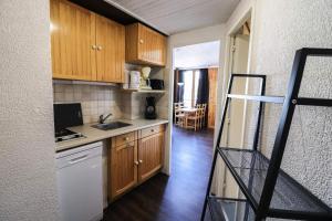 a kitchen with wooden cabinets and a staircase in a room at Résidence Sefcotel - Studio pour 4 Personnes 574 in Tignes