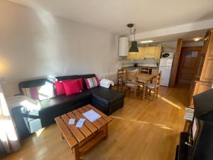 uma sala de estar com um sofá preto e uma mesa em A01 - Anciles Apartamento - Villmor em Anciles