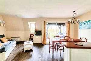 ein Wohnzimmer mit einem Tisch und einem Esszimmer in der Unterkunft La Résidence du Golf - maeva Home - Appartement 2 Pièces 7 Personnes - Pre 654 in Deauville