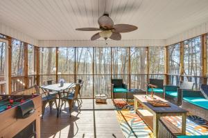 a screened in porch with a pool table and a ceiling fan at Lake Hartwell Retreat with 2-Tier Dock and Boat Slip! in Seneca