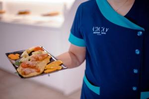 a person holding a tray of food on a plate at Hotel Cicò in Torre Santa Sabina