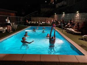 un grupo de personas en una piscina por la noche en Camping Sestola, en Sestola