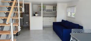 ein Wohnzimmer mit einem blauen Sofa und einer Küche in der Unterkunft Appartement LOFT 40 M2 in Saint-Cyr-sur-Mer