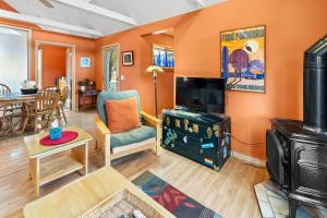 uma sala de estar com paredes cor de laranja e uma sala de estar com televisão em Bluemoon Vacation Rentals - Bluemoon Cottage em Ashland