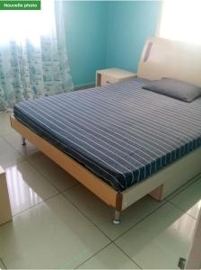 Bett in einem Zimmer mit blauer Wand in der Unterkunft Villa SPIROU in Ivato