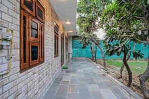 a stone walkway leading to a house with trees at Jain Residency in Greater Noida