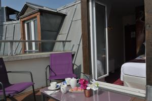 Habitación con balcón con mesa y sillas moradas. en Mercure Paris Place d'Italie en París