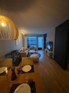 sala de estar con sofá, mesa y sala de estar en Leilighet i Tromsø, en Tromsø