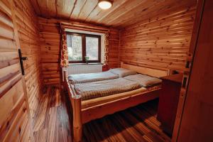a small room with a bed in a log cabin at Jánošíková chata Orava in Námestovo