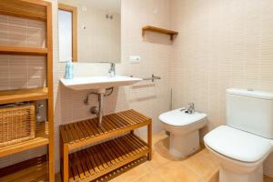 ein Badezimmer mit einer weißen Toilette und einem Waschbecken in der Unterkunft Port de Llançà 44 Apartamento moderno con terraza in Llança + 17 Fotos