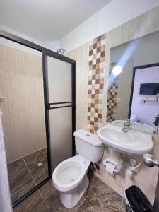 a bathroom with a toilet and a sink at Nativos Hospedaje in Medellín