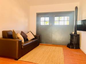 uma sala de estar com um sofá de couro e uma porta em Quinta da Bela Vista em Lagos