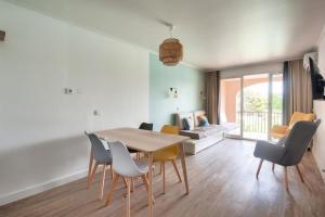 een woonkamer met een eettafel en stoelen bij Village Pont Royal en Provence - maeva Home - Appartement 2 pièces 4 person 154 in Mallemort