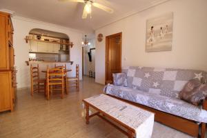 uma sala de estar com um sofá e uma mesa em Elvira Home, apartamento en La Mata, Torrevieja AQ-120 em La Mata