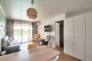 un salon avec une table et des chaises en bois dans l'établissement Village Pont Royal en Provence - maeva Home - Appartement cosy et climatisé 2 pièces 4 personnes - Sélection - super Home MAE-2154, à Mallemort
