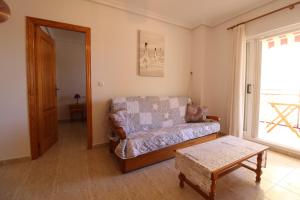 uma sala de estar com um sofá e uma mesa em Elvira Home, apartamento en La Mata, Torrevieja AQ-120 em La Mata