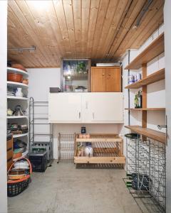a kitchen with wooden ceilings and wooden shelves at Casa Bubeck in Cavagnago