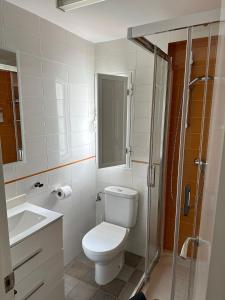 a bathroom with a toilet and a sink and a shower at Apartamento en el casco histórico in Tarifa