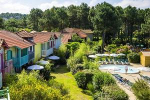 ein Resort mit einem Pool, Stühlen und Sonnenschirmen in der Unterkunft Les Maisons de Lacanau les Pins - maeva Home - Maison 3 pièces 6 personnes 624 in Lacanau
