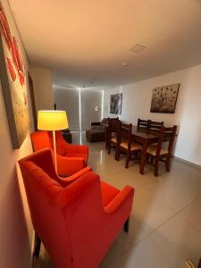 sala de estar con sillas rojas y comedor en santisima cen1 en Asunción