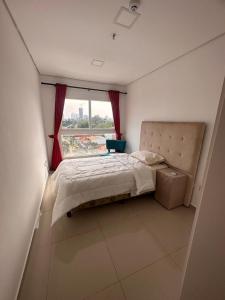 1 dormitorio con cama y ventana grande en santisima cen1 en Asunción