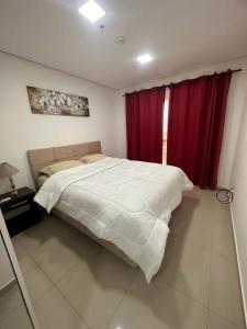 1 dormitorio con 1 cama grande y cortinas rojas en santisima cen1 en Asunción
