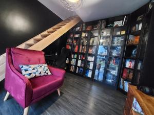 un soggiorno con una sedia rossa e una libreria di Grande suite & salon privé, proche du circuit a Magny-Cours