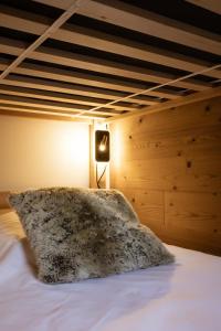 a bed with a furry pillow on top of it at Chalet Lova in Valloire