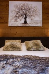 uma cama com duas almofadas e uma foto de uma árvore em Chalet Lova em Valloire