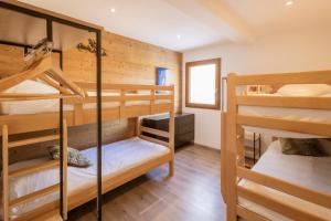 a room with three bunk beds in a cabin at Chalet Lova in Valloire