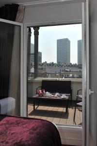 uma varanda com uma mesa e vista para a cidade em Mercure Paris Place d'Italie em Paris